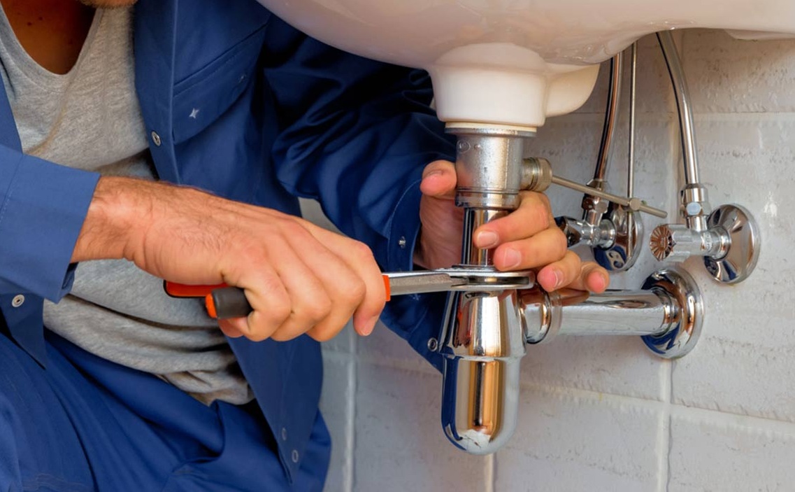 Fontanero reparando una tubería en instalación doméstica